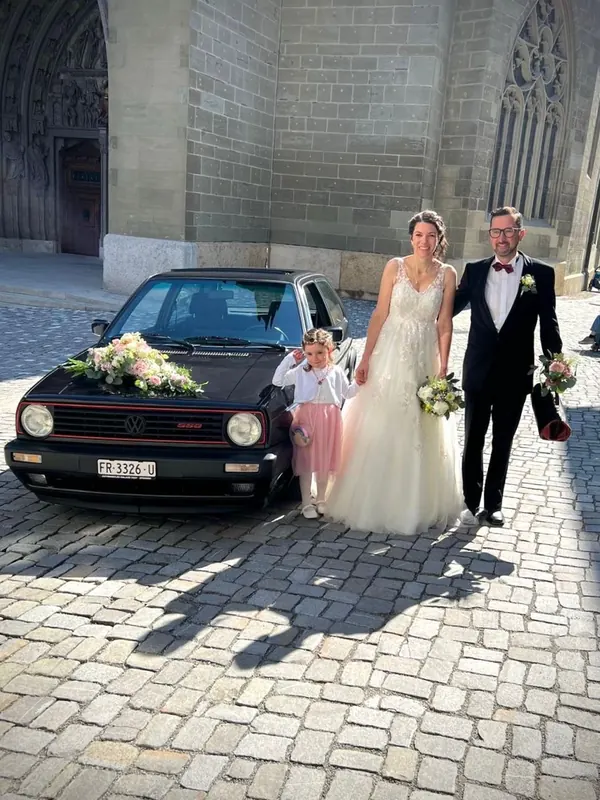 Couple de mariés en tenue de gala devant la cathédrale de Fribourg